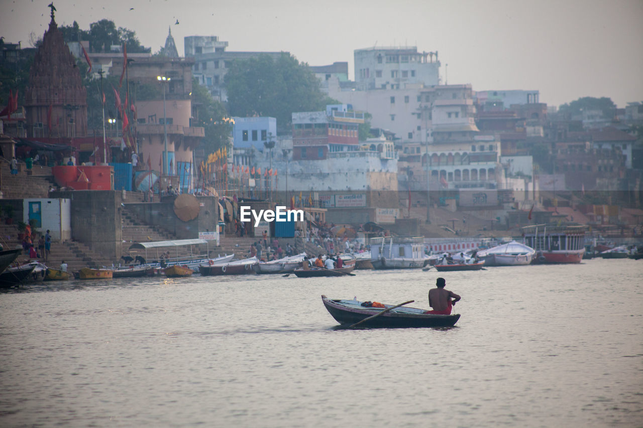 Boats in canal amidst buildings in city