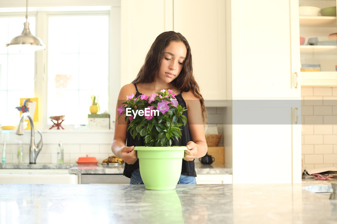 Girl looking at plants over table