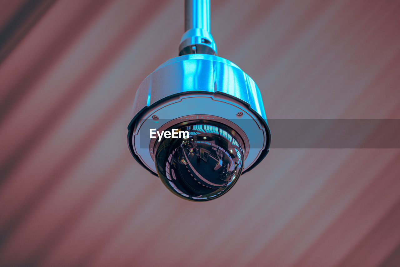 Low angle view of security camera hanging from ceiling