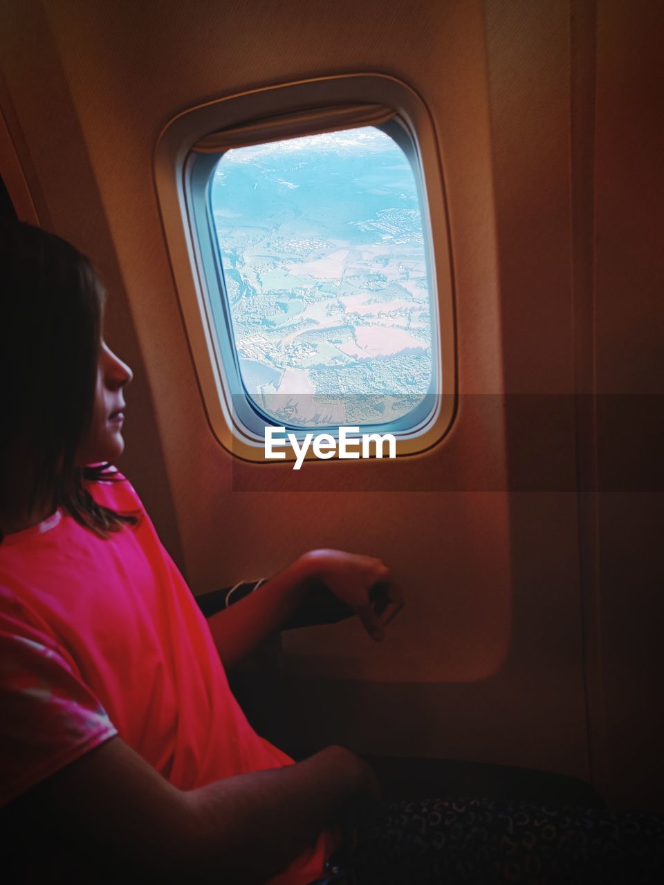 Rear view of woman sitting in plane