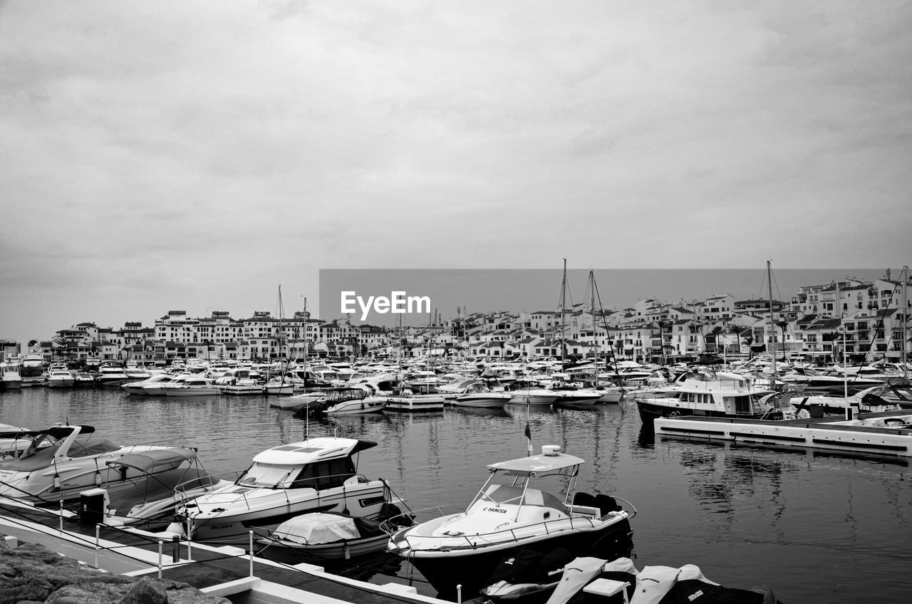 BOATS MOORED AT HARBOR IN CITY