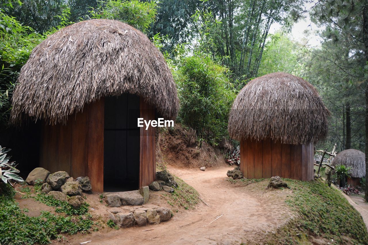 PANORAMIC SHOT OF COTTAGE BY TREES AND HOUSES