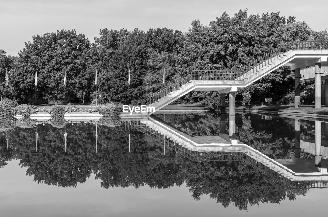 Reflection of trees and stairs in lake 
