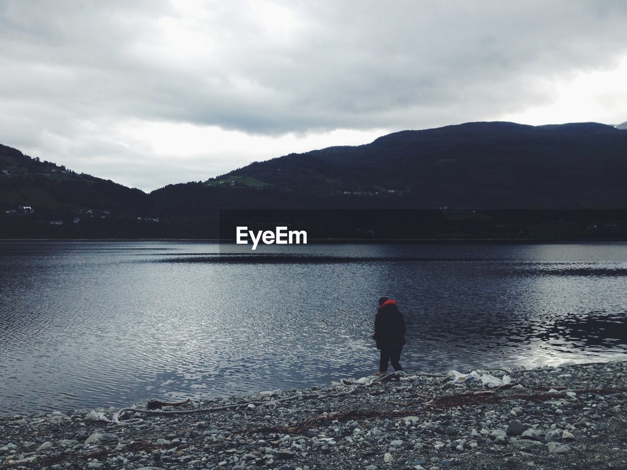 Scenic view of lake and mountains against cloudy sky