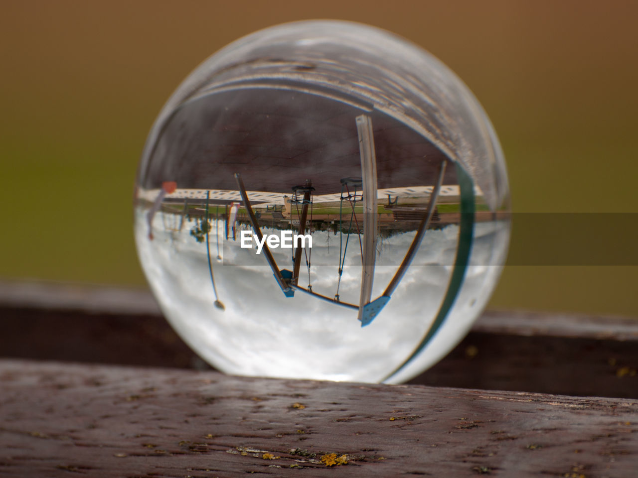 CLOSE-UP OF GLASS CONTAINER WITH REFLECTION ON METAL TABLE