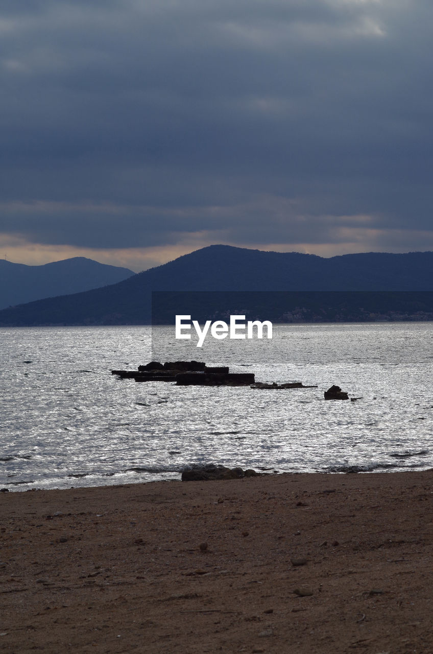 SCENIC VIEW OF SEA BY MOUNTAINS AGAINST SKY