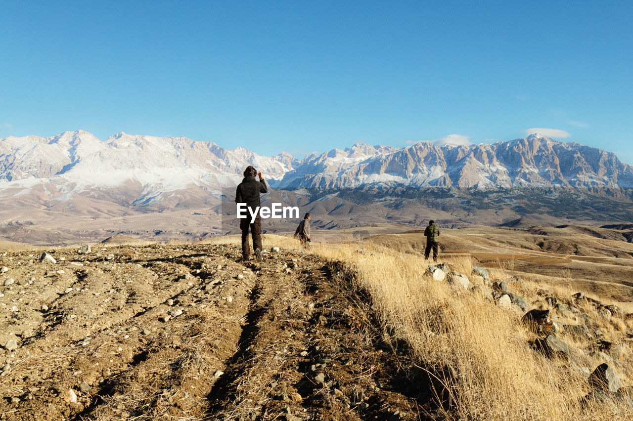 FULL LENGTH OF A MAN ON LANDSCAPE AGAINST SKY