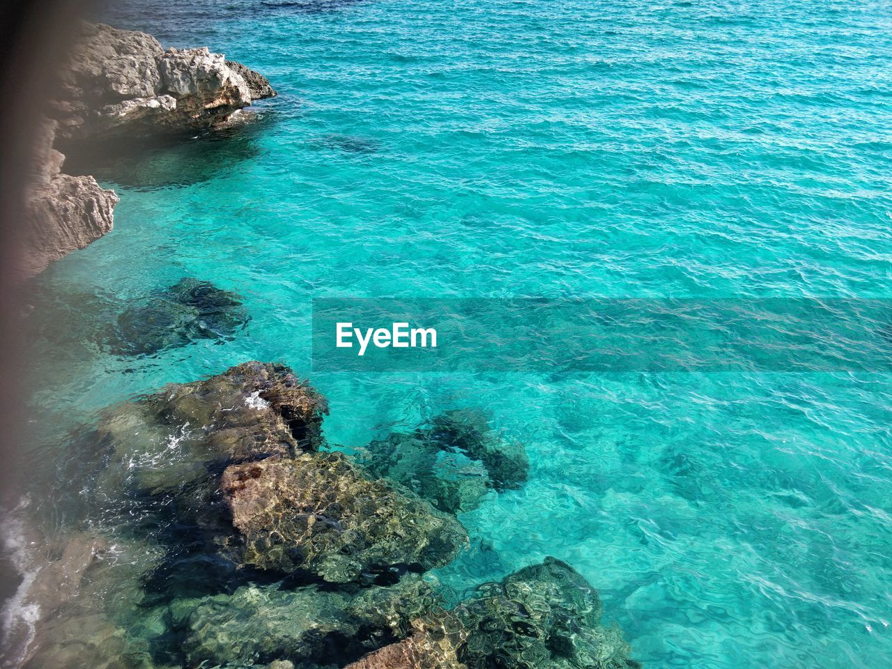 HIGH ANGLE VIEW OF ROCK FORMATIONS IN SEA