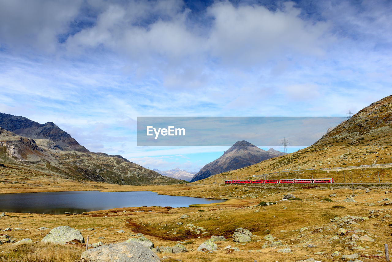 SCENIC VIEW OF LAKE BY MOUNTAIN AGAINST SKY