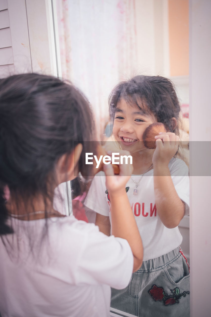 Beautiful little girl plays doing makeup