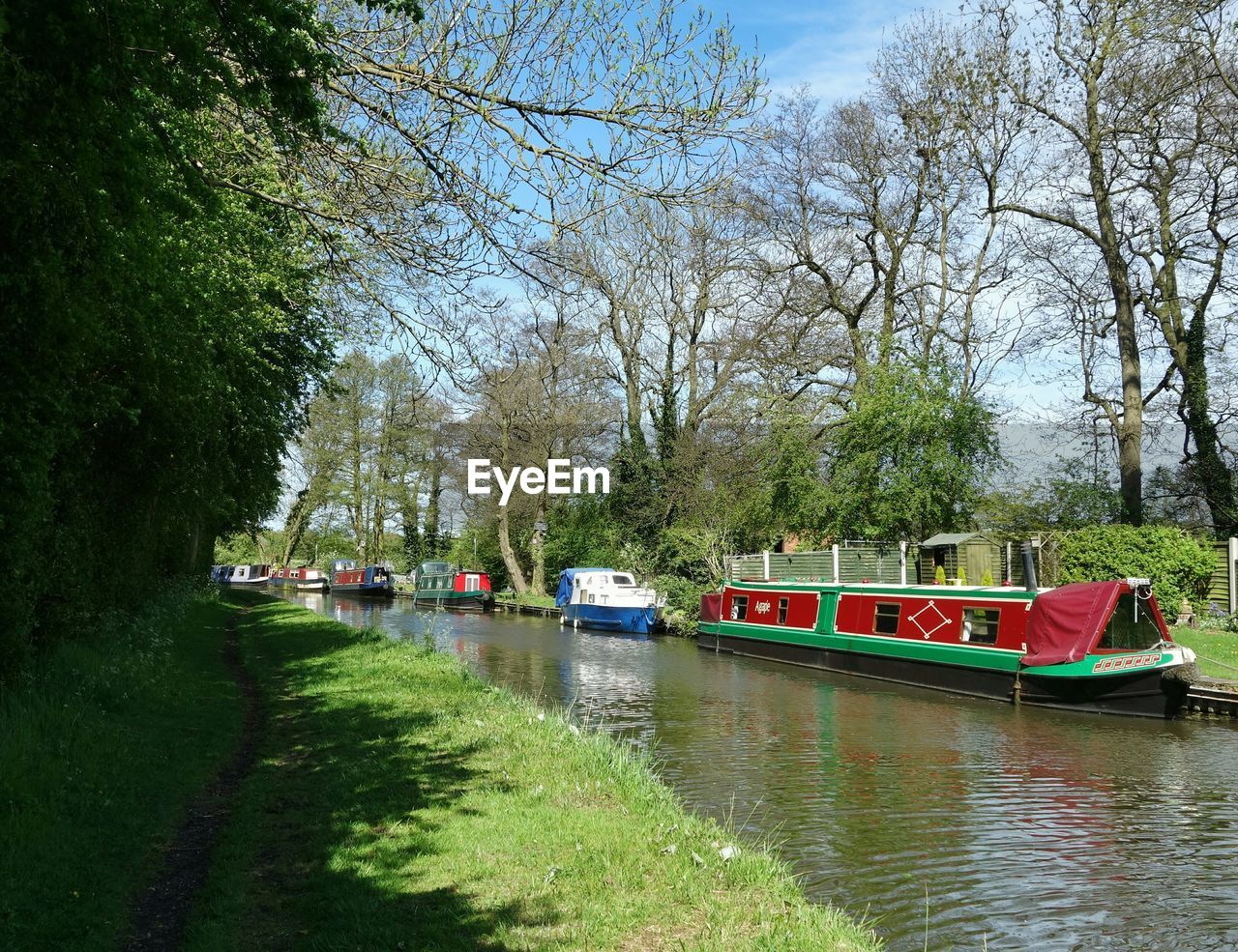 Barge boats sailing in canal amidst trees