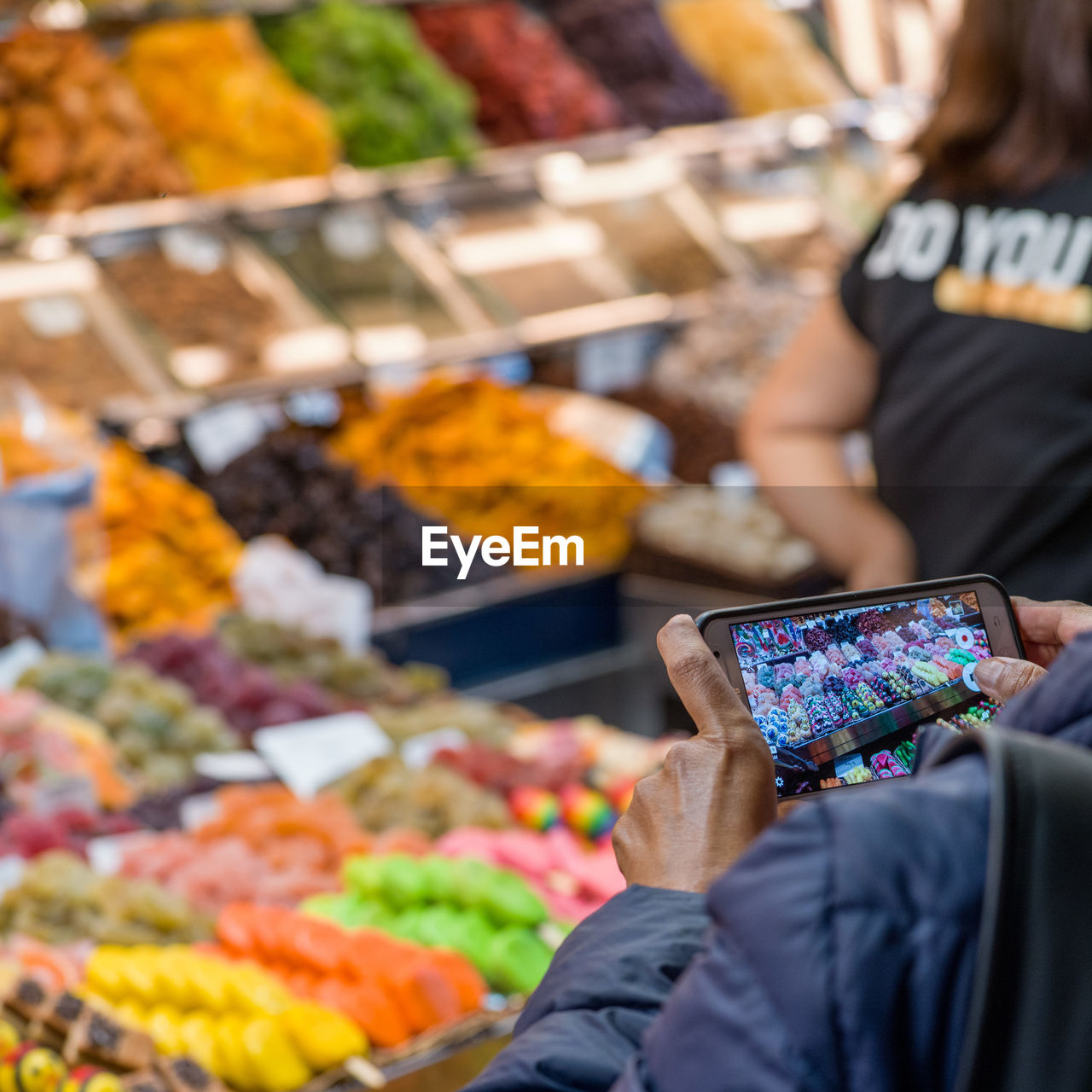 Close-up of woman photographing food at market stall