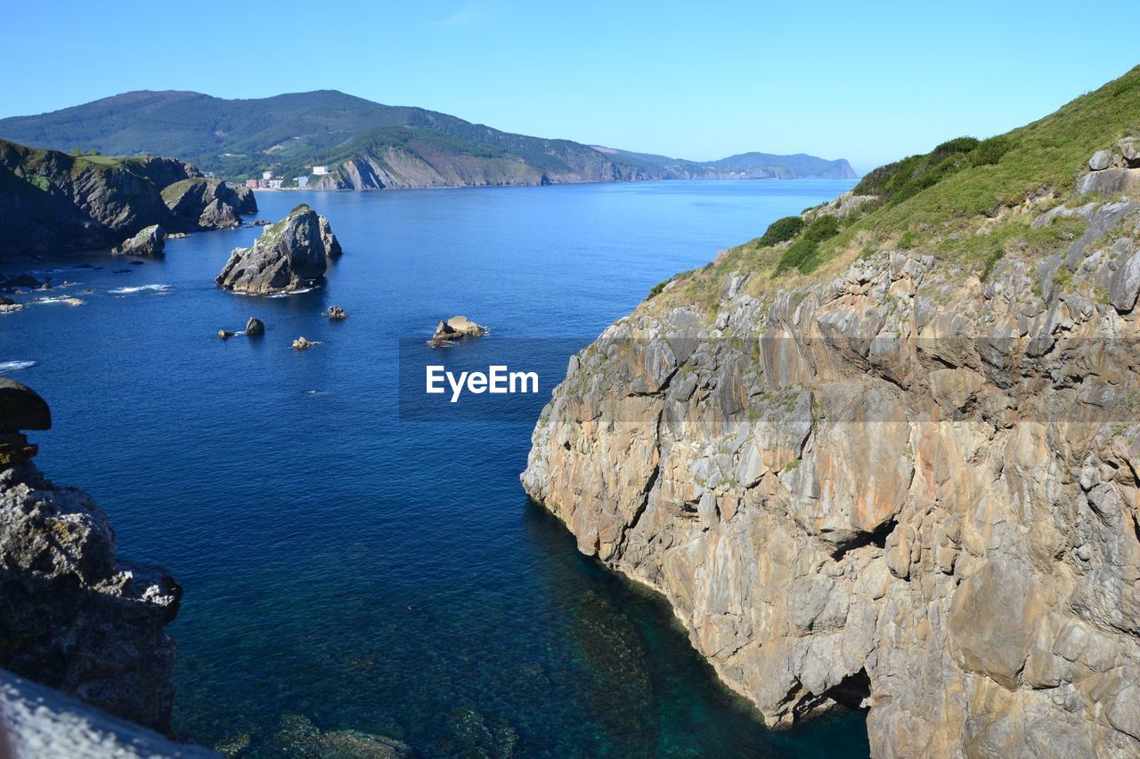 Scenic view of sea and mountains against sky