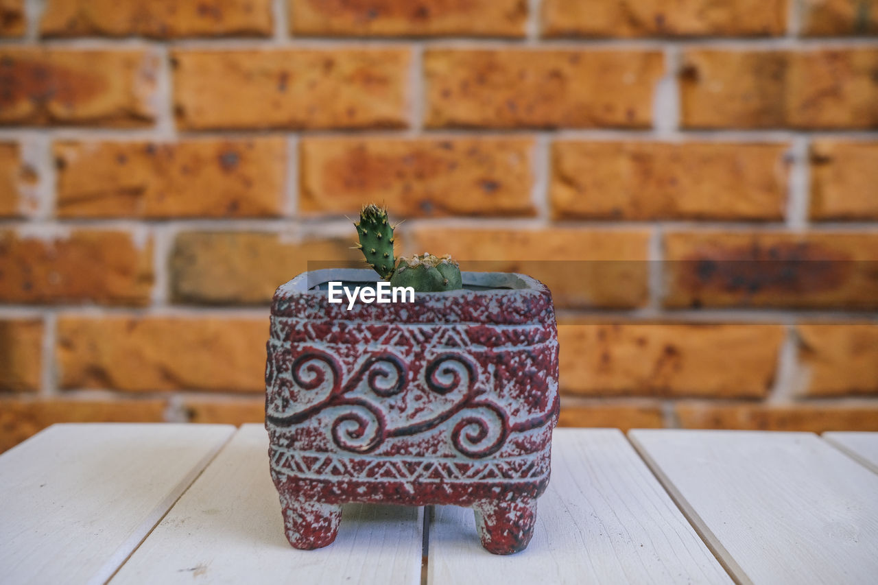 brick wall, brick, wall, no people, pattern, wall - building feature, wood, indoors, table, seat, focus on foreground, food and drink, decoration, art, architecture