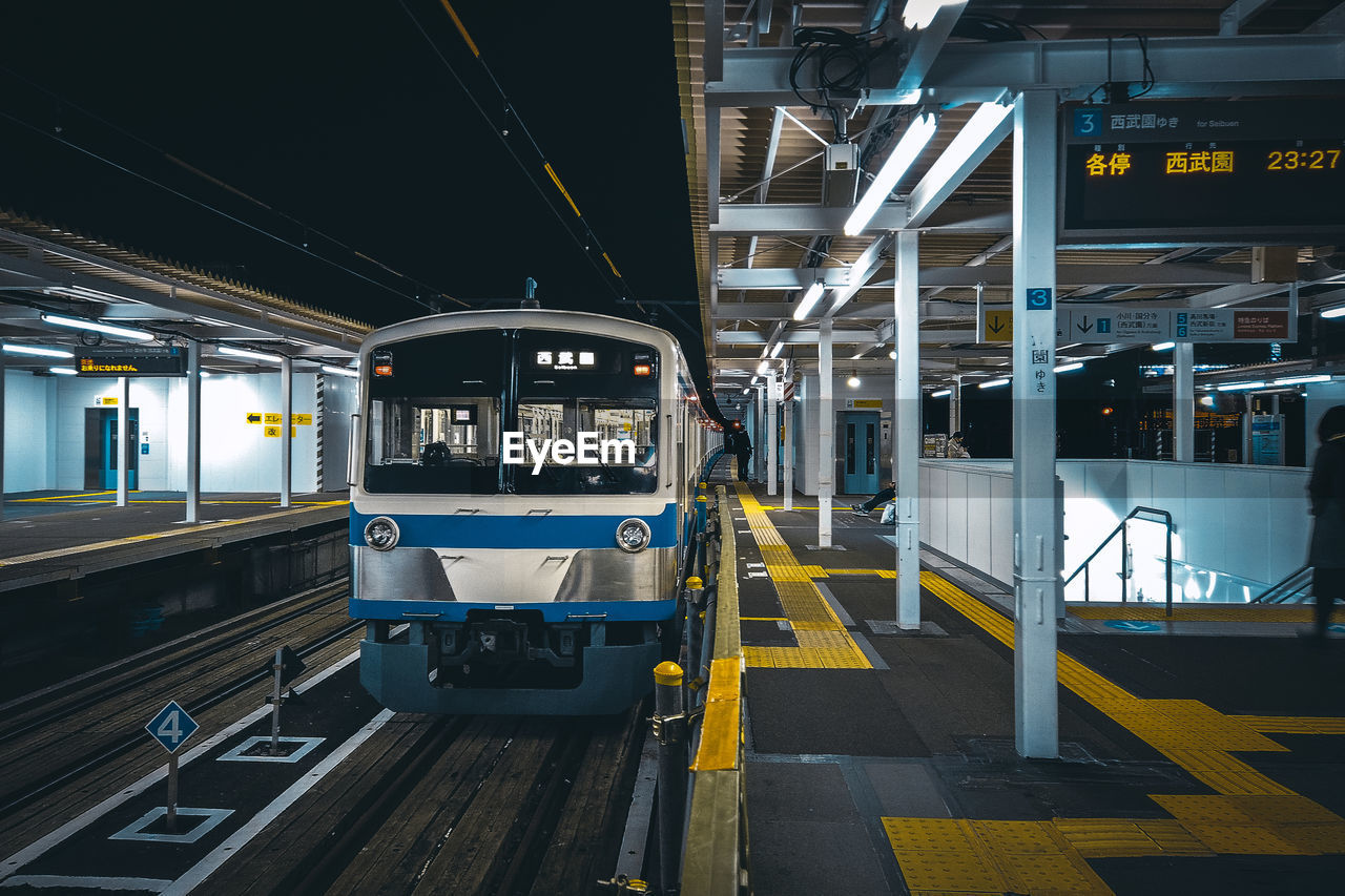 Train at railroad station platform at night