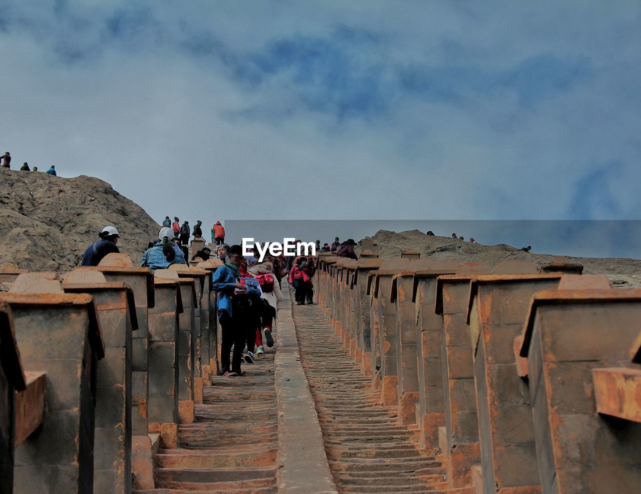 GROUP OF PEOPLE WALKING ON STEPS OF MOUNTAIN