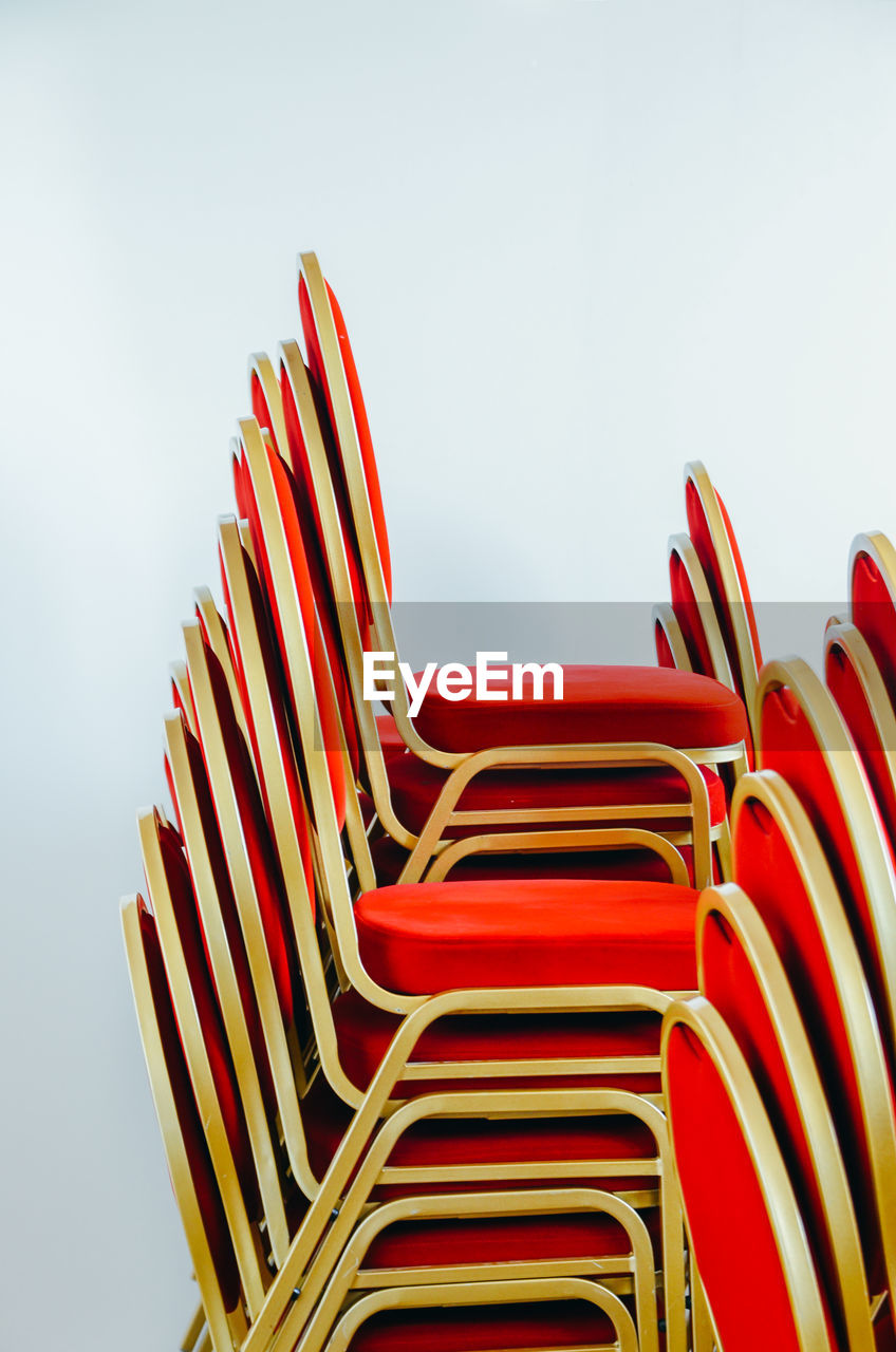 Red chairs stacked against white background