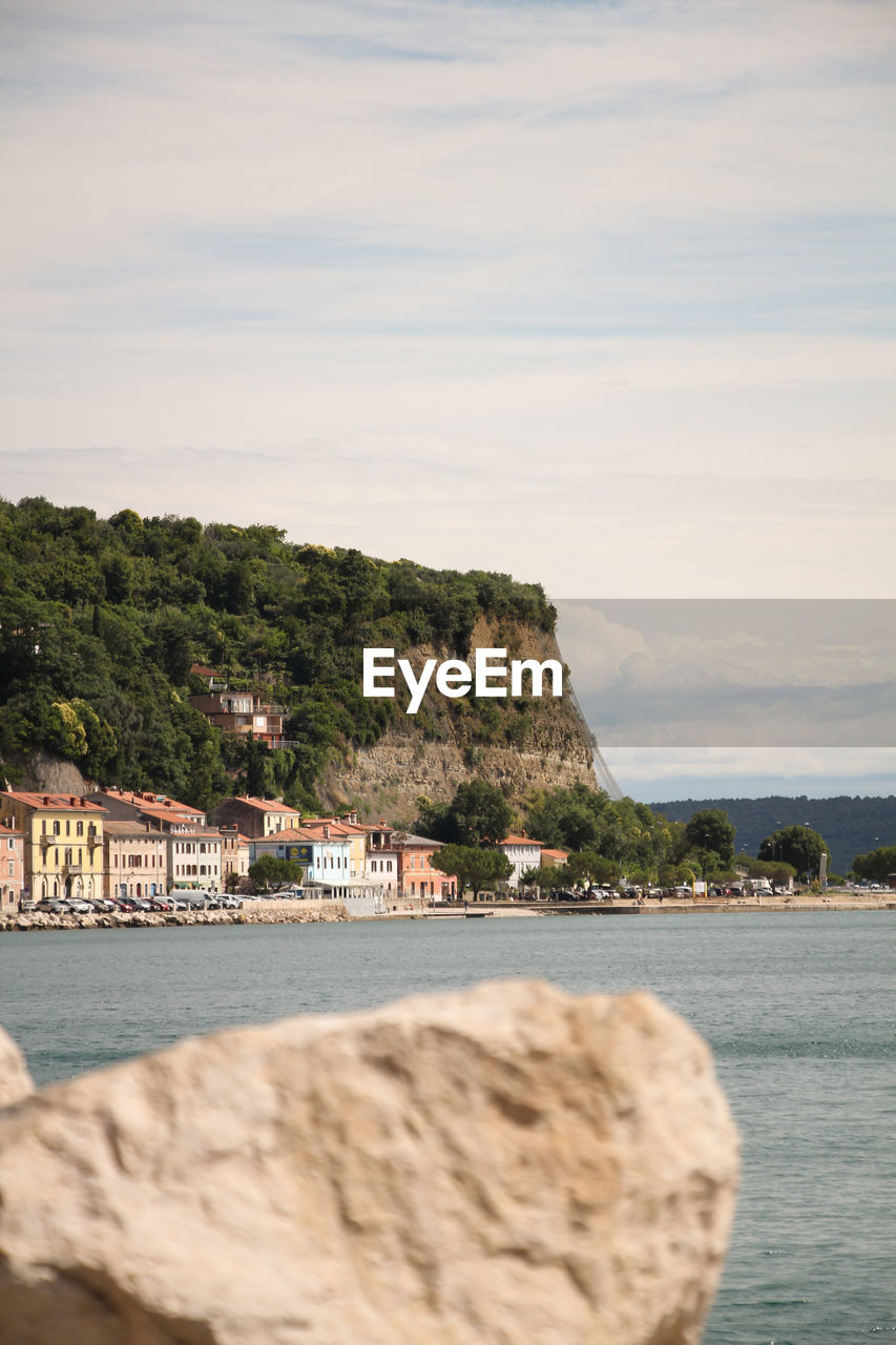 Scenic view of sea by buildings against sky