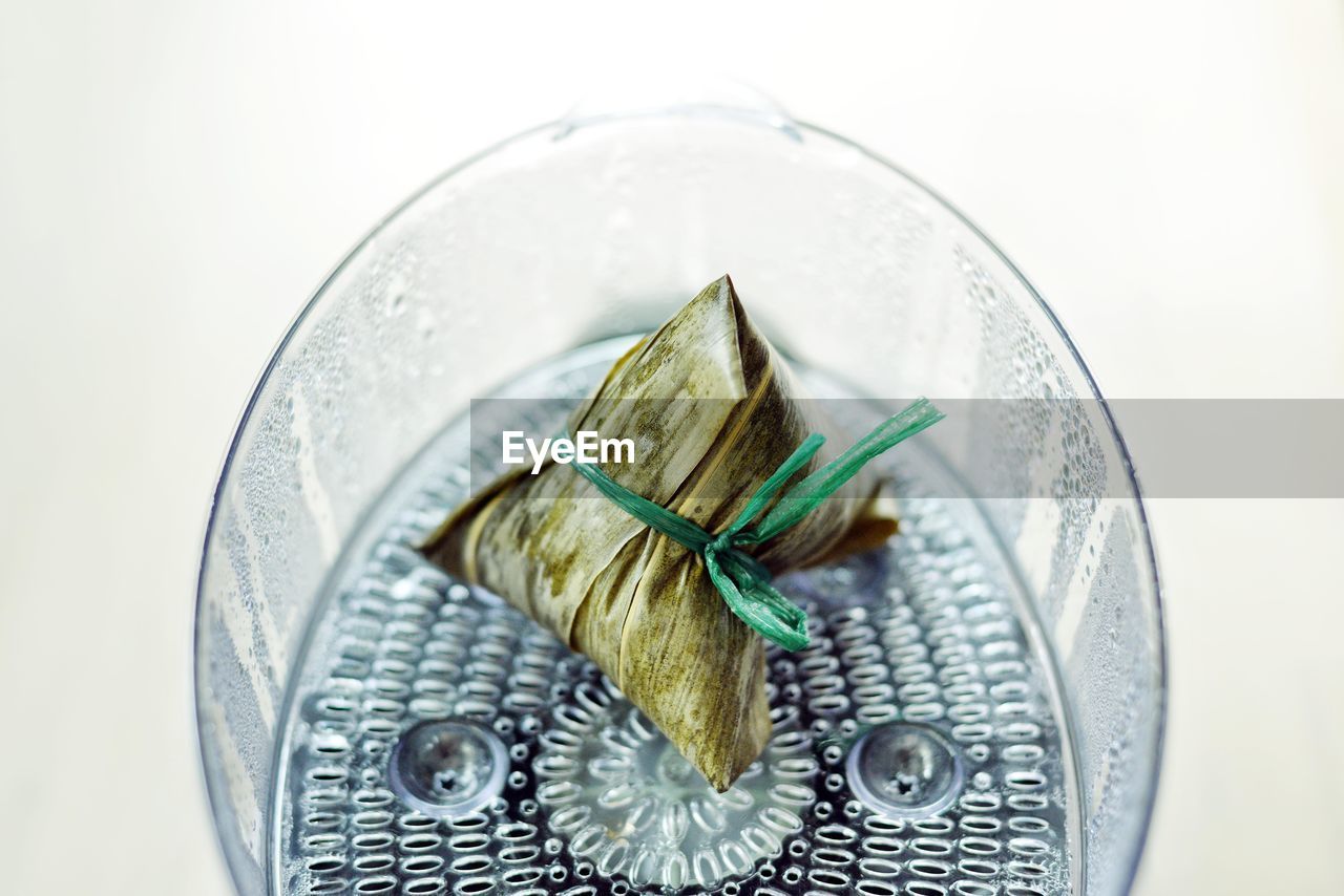 High angle view of food in a steamer against white background