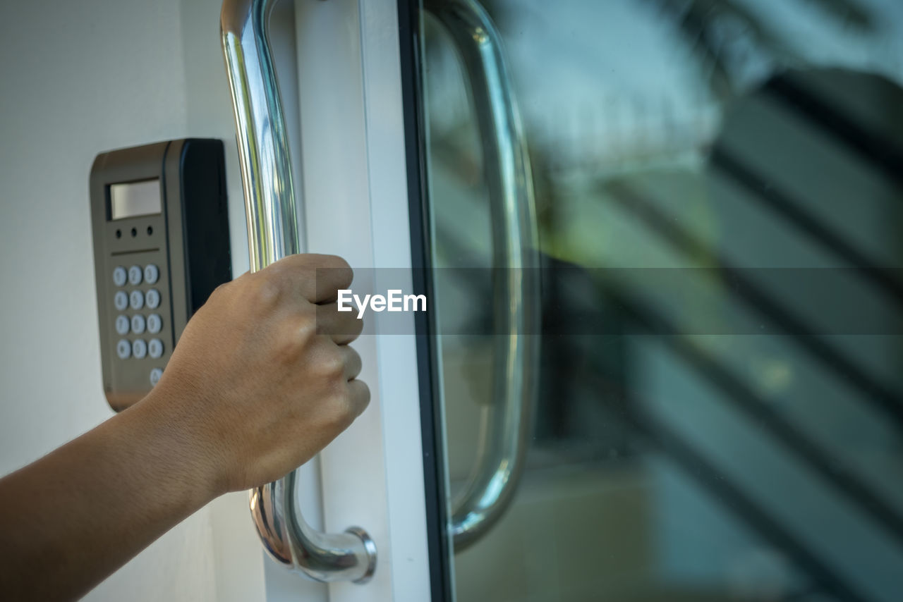 Cropped hand holding door handle