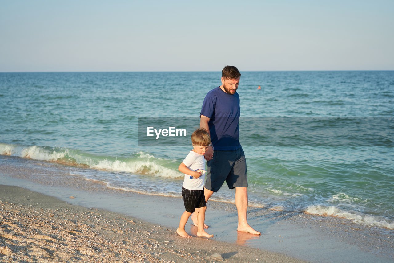 Full length of father and son on beach