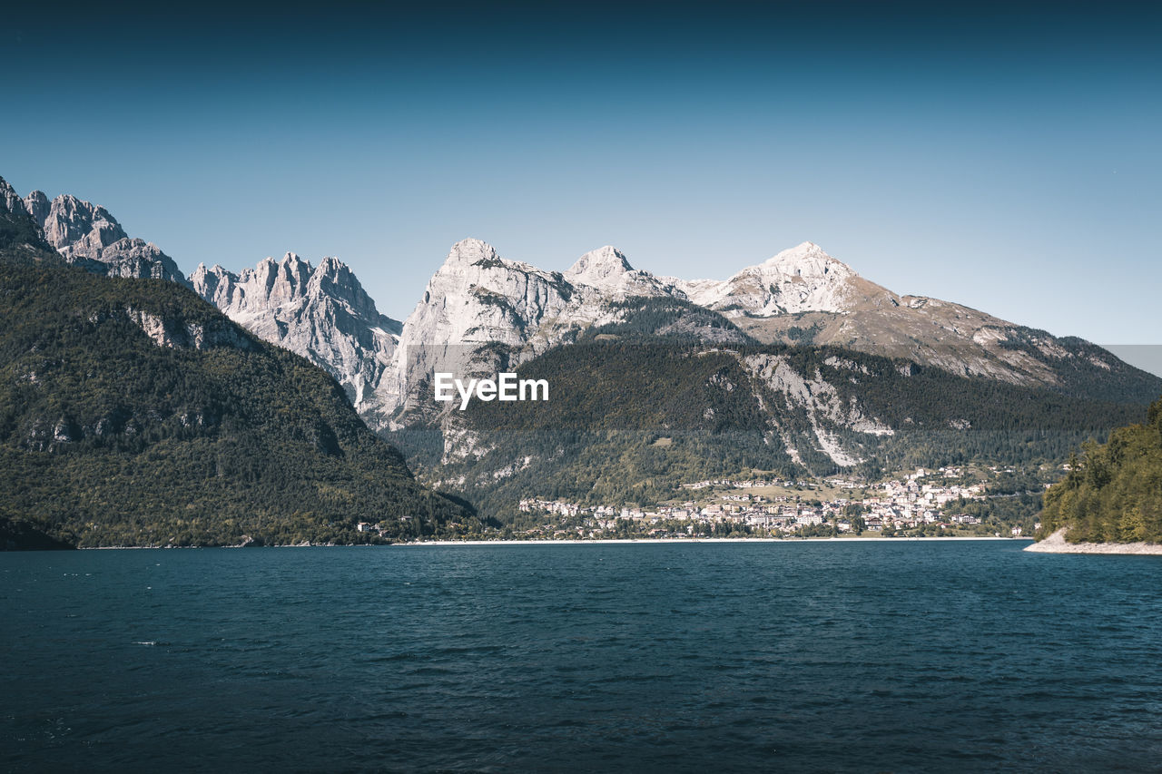 Scenic view of snowcapped mountains and sea against clear sky