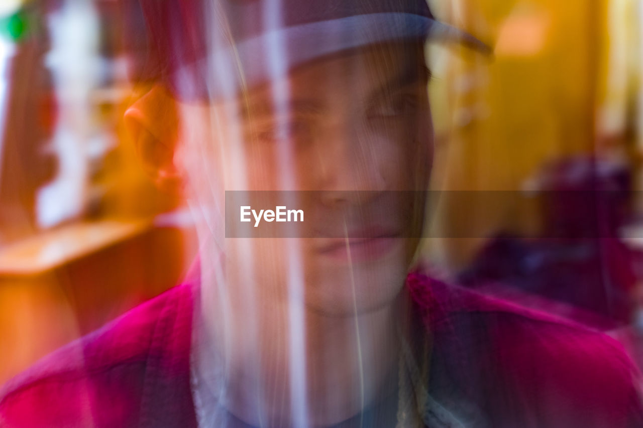 Young man reflecting on window