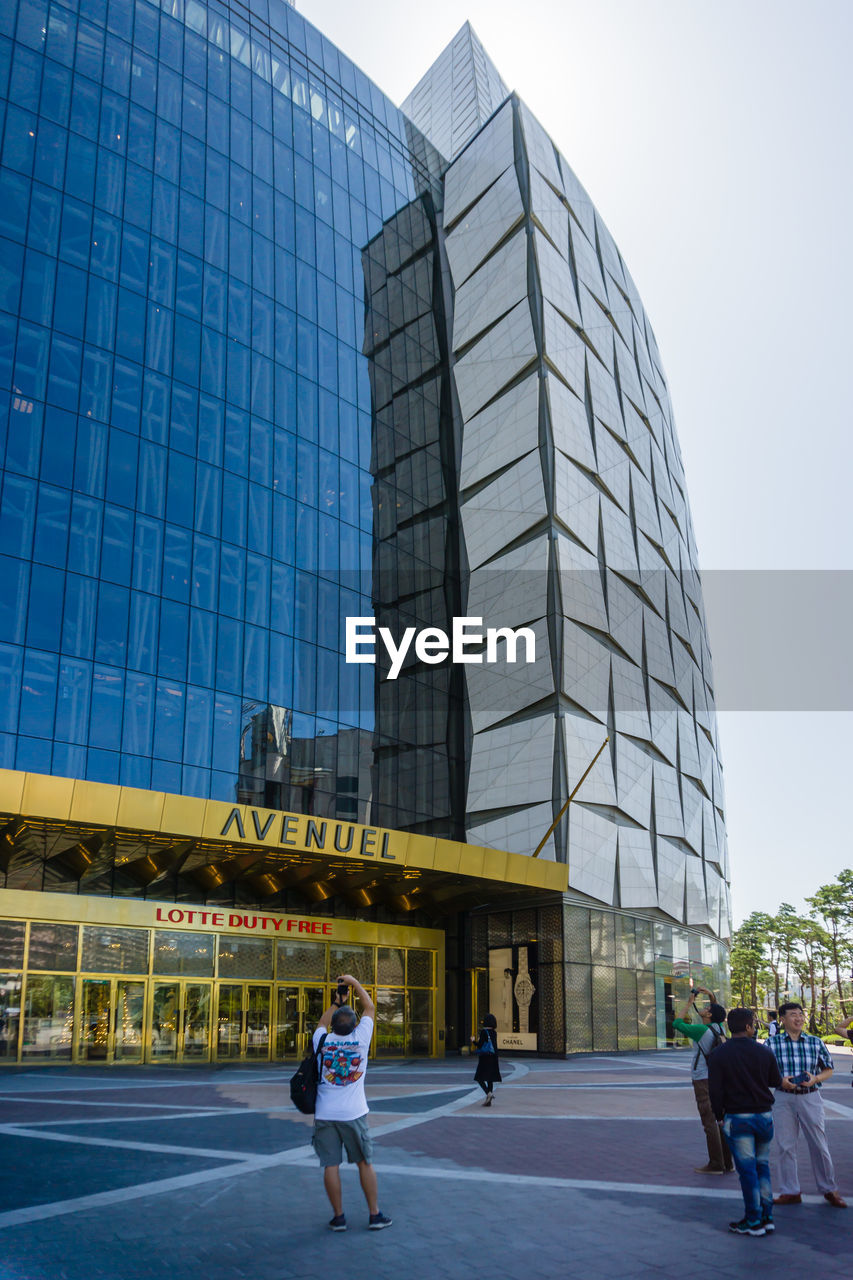 PEOPLE WALKING ON MODERN GLASS BUILDING