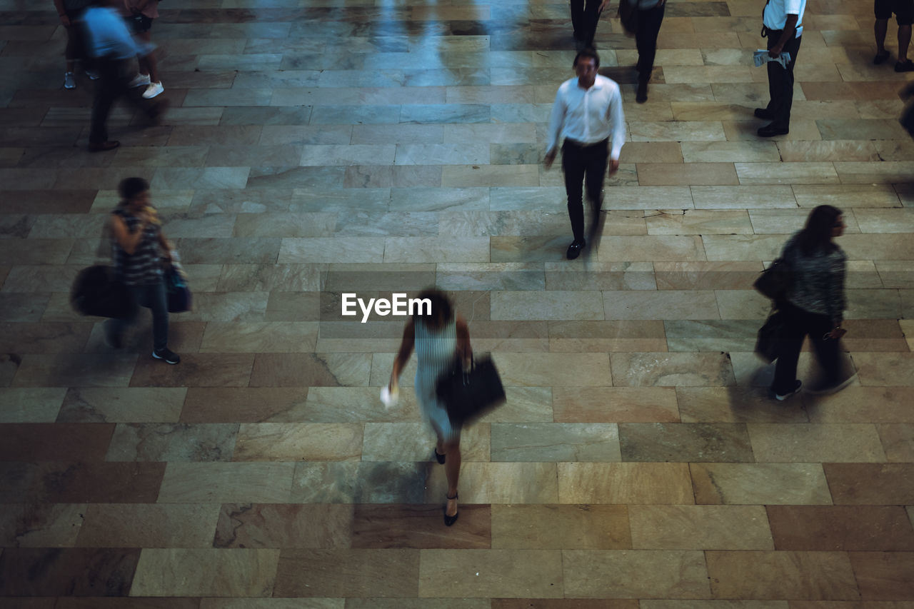 Blurred motion of people walking on floor in city