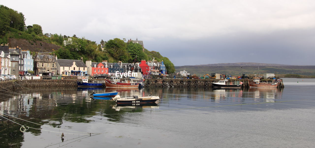 Boats moored in river against built structures