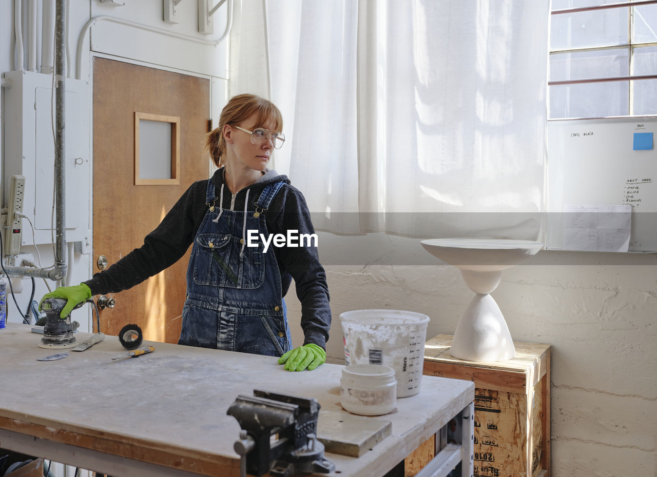 Professional female sculptor working in her studio