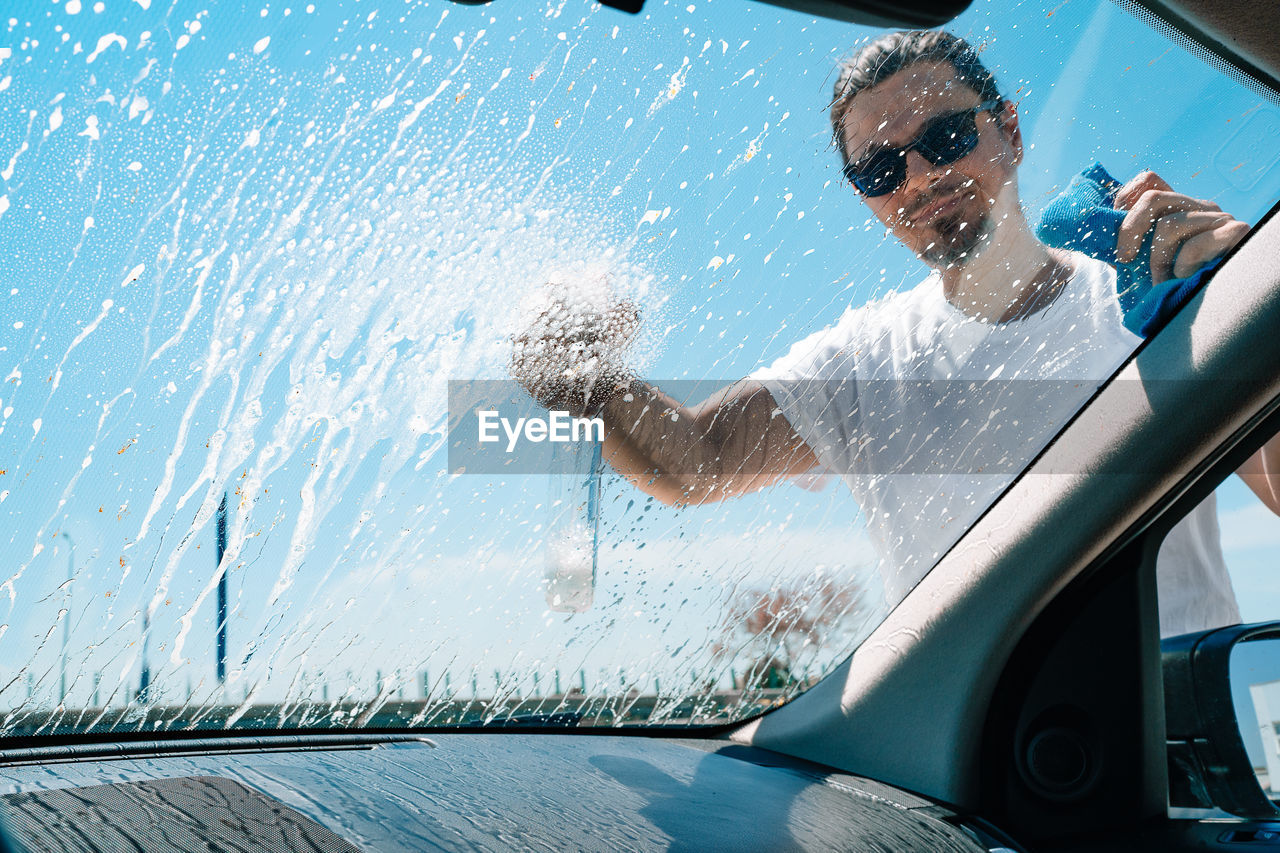 Man washing car windshield