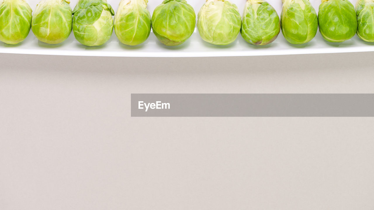 food, food and drink, healthy eating, wellbeing, copy space, freshness, green, produce, indoors, vegetable, in a row, no people, studio shot, still life, plant, brussels sprout, order, side by side, group of objects, close-up, fruit, organic, large group of objects