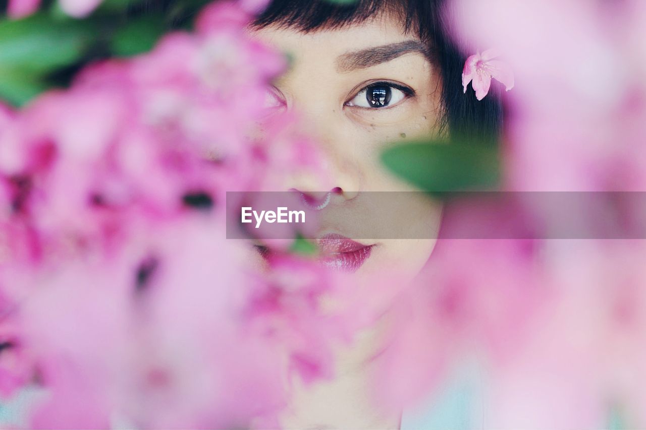 Close-up portrait of woman amidst flowers