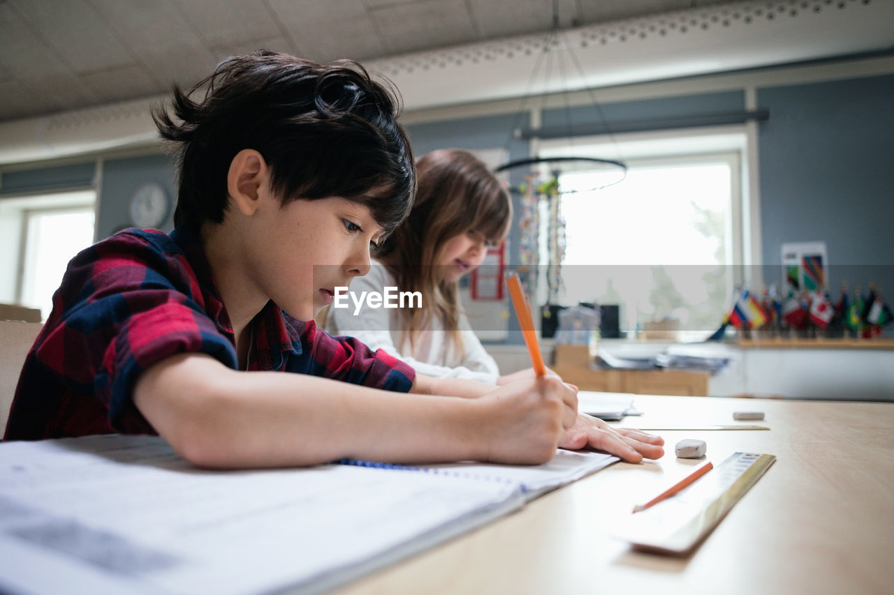Serious students studying at desk in classroom