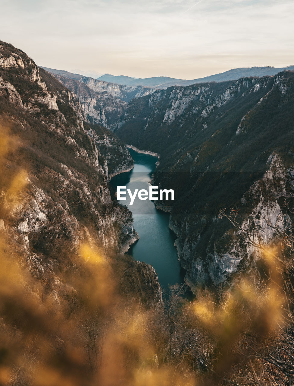 Scenic view of river amidst mountains against sky