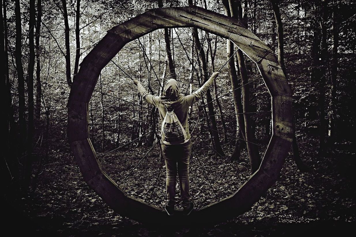 Young woman climbing metallic circle