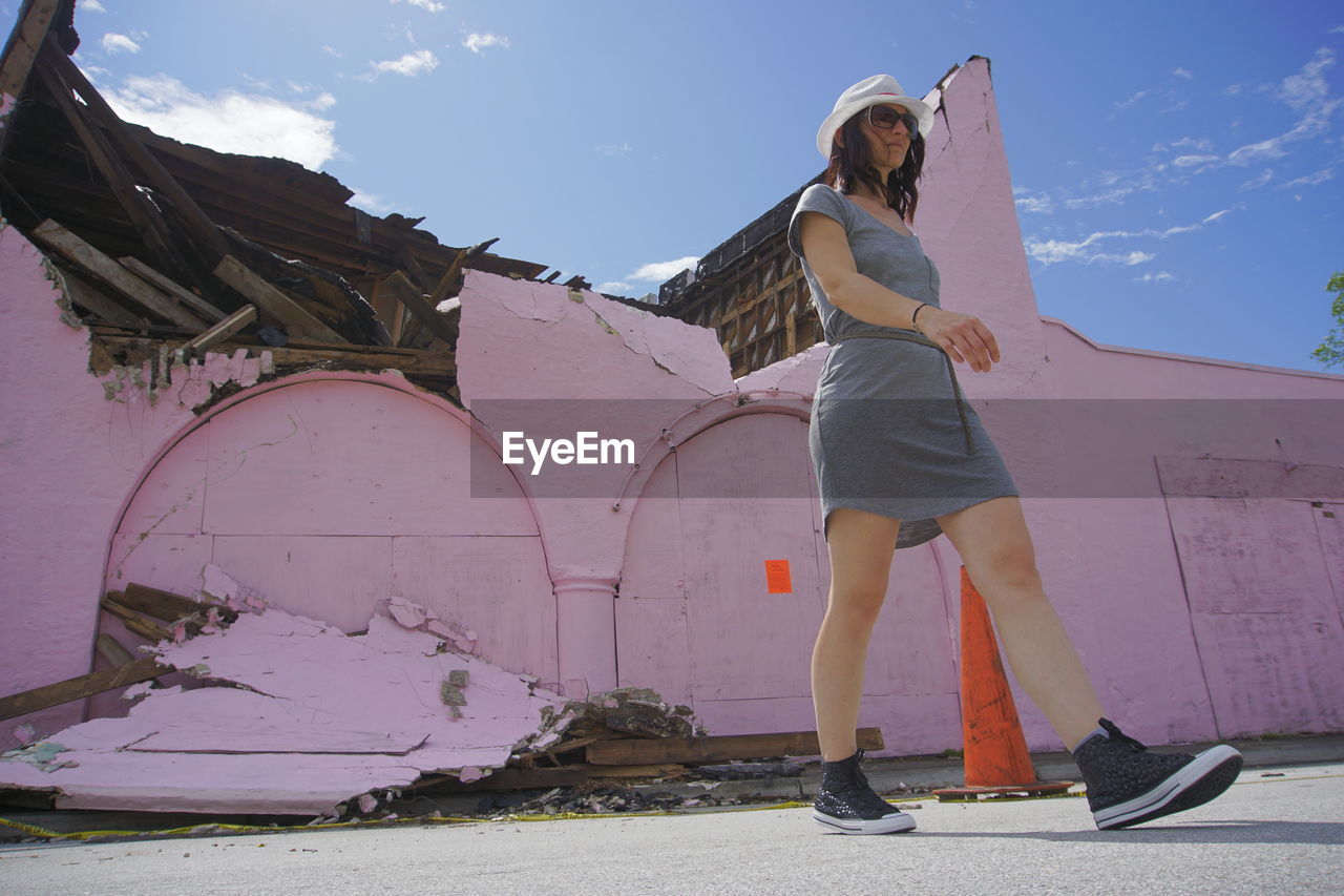 Full length of mid adult woman walking on street against sky