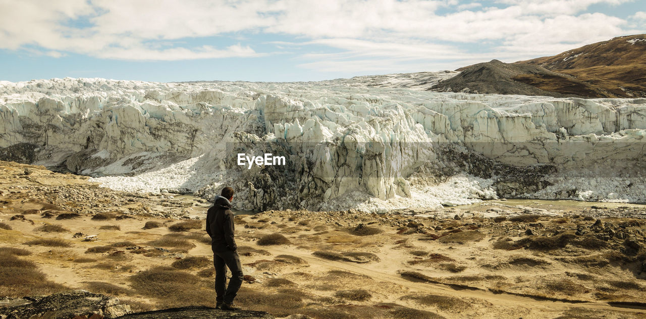 Man standing against snowcapped mountains