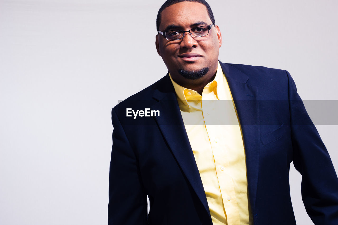 Portrait of businessman standing against white background