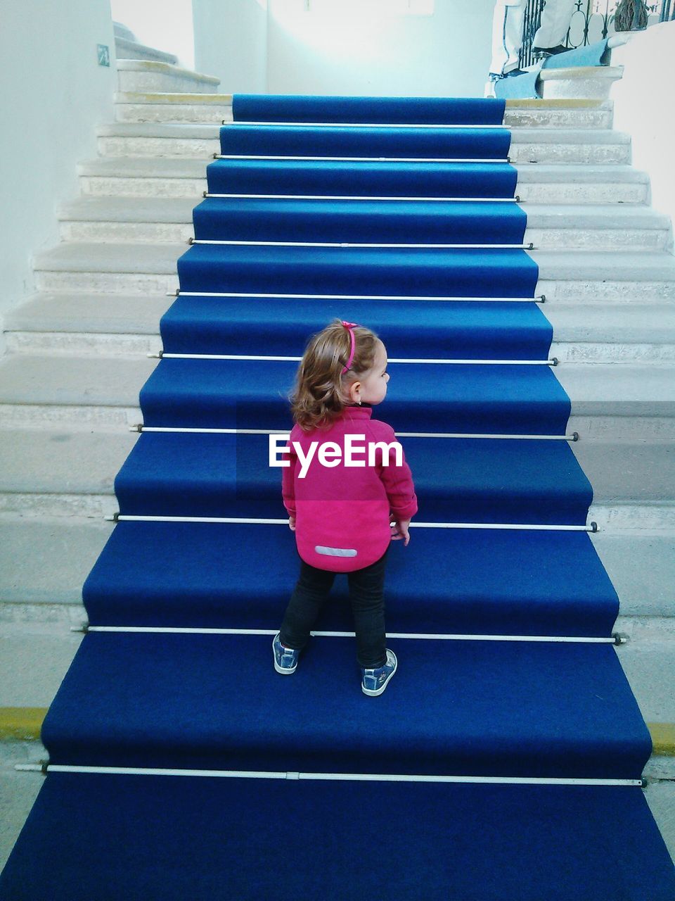 Rear view of girl standing on staircase