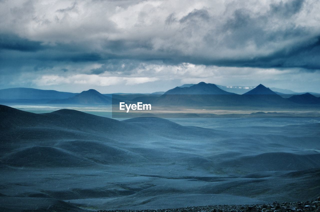 Scenic view of mountains against cloudy sky