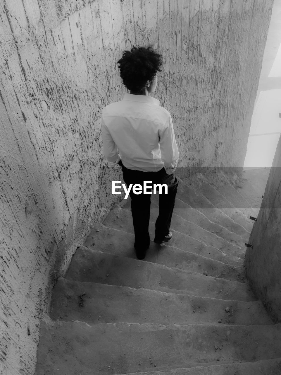 white, black, one person, full length, black and white, architecture, rear view, wall - building feature, monochrome, monochrome photography, staircase, casual clothing, standing, built structure, adult, snapshot, lifestyles, leisure activity, men, women, day, steps and staircases, wall, walking, indoors, young adult, shadow