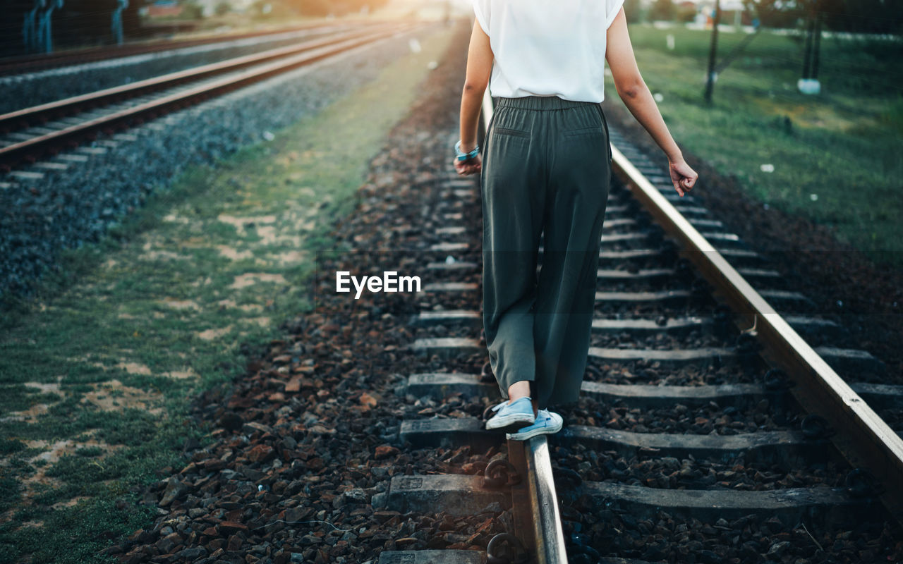 Low section of man standing on railroad track