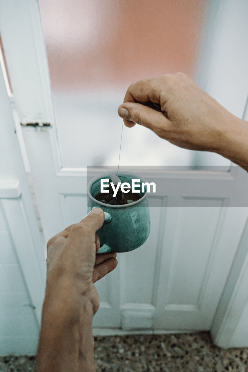 MIDSECTION OF PERSON PREPARING FOOD IN KITCHEN