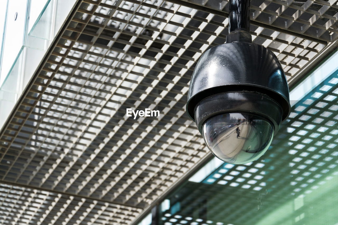 LOW ANGLE VIEW OF ILLUMINATED LAMP HANGING ON CEILING IN BUILDING