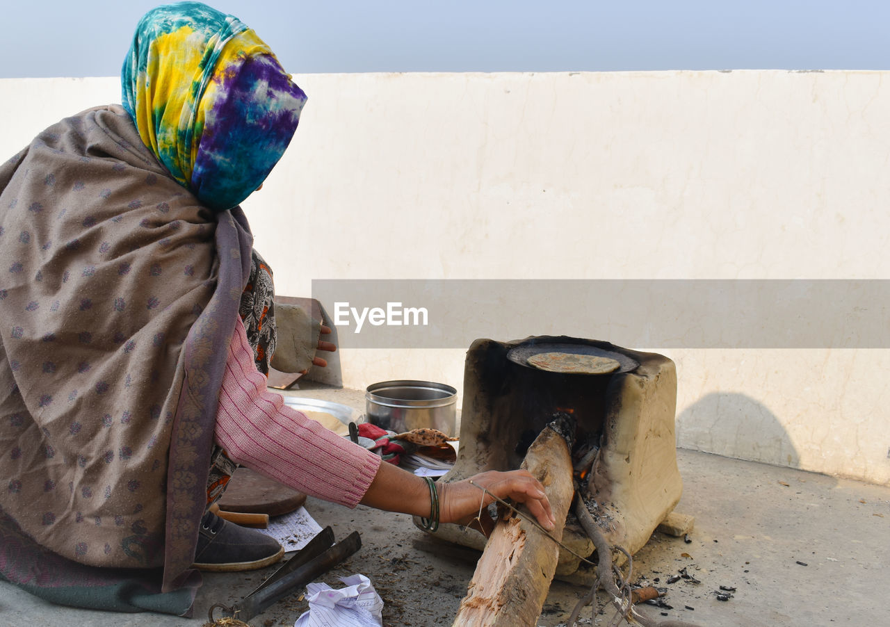 Rural woman cooking food on fire wood