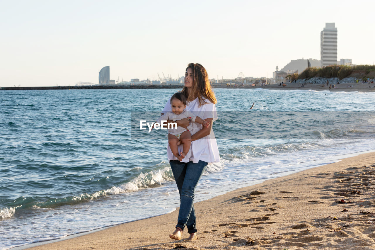 rear view of young woman standing at beach