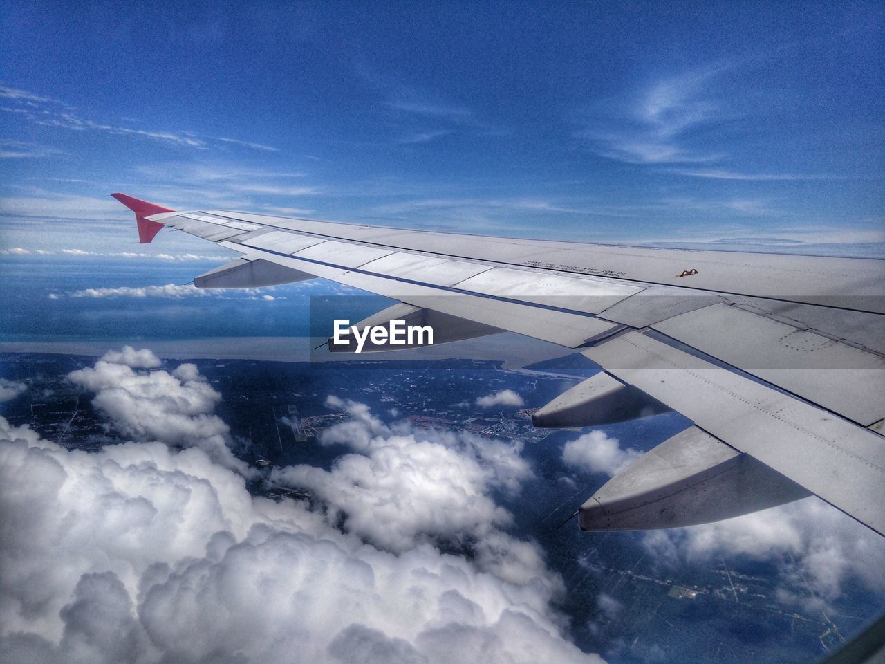 AERIAL VIEW OF AIRPLANE WING OVER CLOUDSCAPE