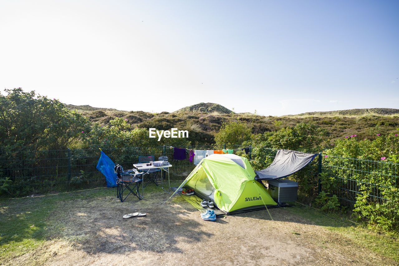 TENT ON FIELD AGAINST CLEAR SKY